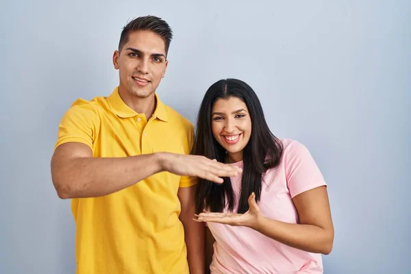 Young Couple Standing Isolated Background Gesturing Hands Showing Big Large — Foto de Stock