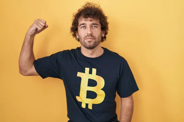Hispanic Young Man Wearing Bitcoin Shirt Strong Person Showing Arm — Foto de Stock