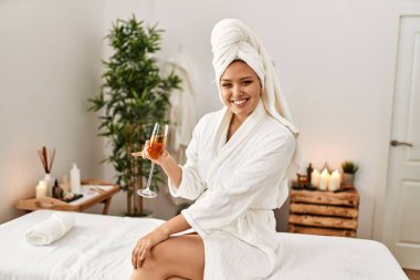 Güzel İspanyol kadın bornoz giyiyor. Güzellik salonunda şampanya içiyor.