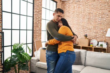 Erkek ve kadın çift yeni evlerinde birbirlerine sarılıyorlar.