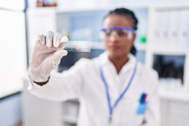 African american woman scientist holding sample at street