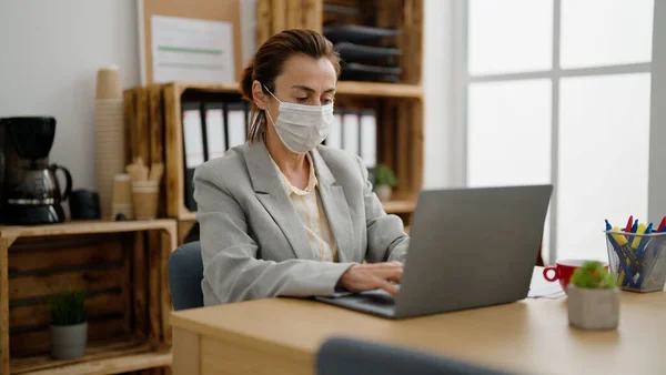 stock image Middle age hispanic woman business worker wearing medical mask working at office