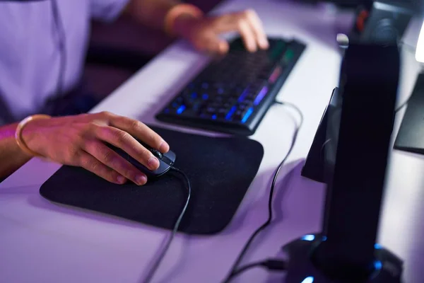 Young caucasian man using computer keyboard and mouse at gaming room