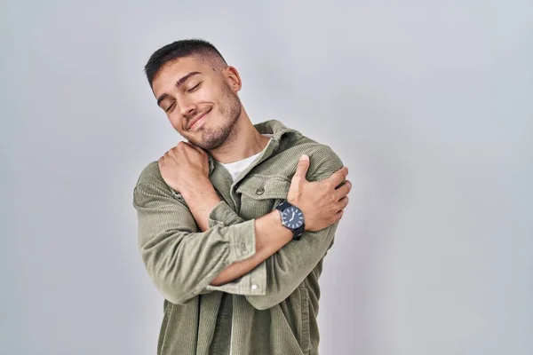 Young Hispanic Man Standing Isolated Background Hugging Oneself Happy Positive — Stock fotografie