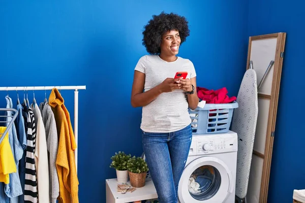 洗濯室で洗濯機を待つアフリカ系アメリカ人女性 — ストック写真