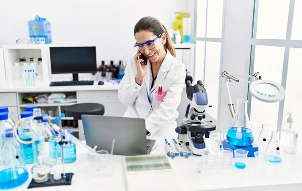 Young Hispanic Woman Wearing Scientist Uniform Talking Smartphone Laboratory — Stock Photo, Image