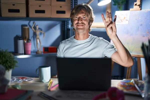 Middle Age Man Sitting Art Studio Laptop Night Showing Pointing — 图库照片