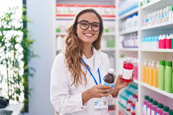 Joven Hermosa Mujer Hispana Farmacéutica Sonriendo Confiada Sosteniendo Botellas Medicamentos — Foto de Stock