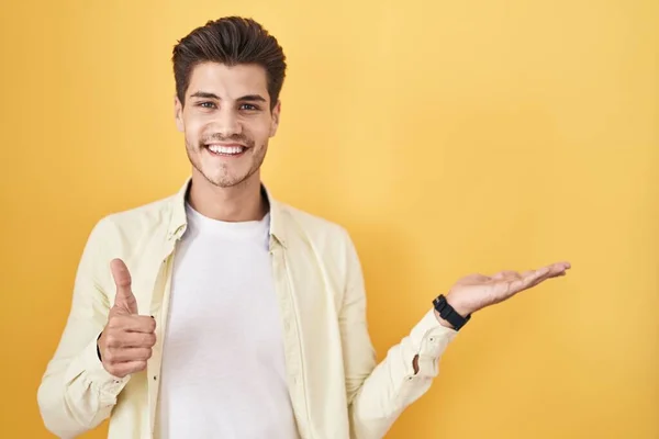 Young Hispanic Man Standing Yellow Background Showing Palm Hand Doing — Stockfoto