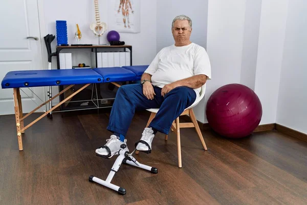 Senior Caucasian Man Physiotherapy Clinic Using Pedal Exerciser Puffing Cheeks —  Fotos de Stock
