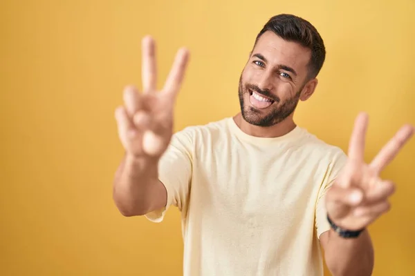 Handsome Hispanic Man Standing Yellow Background Smiling Tongue Out Showing —  Fotos de Stock