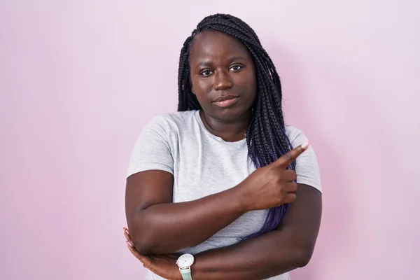 Young African Woman Standing Pink Background Pointing Hand Finger Side — Foto Stock