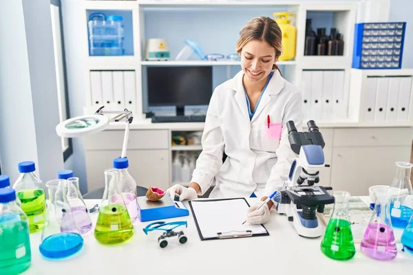 Young Hispanic Woman Scientist Weighing Gemstone Writing Report Laboratory — Stok fotoğraf