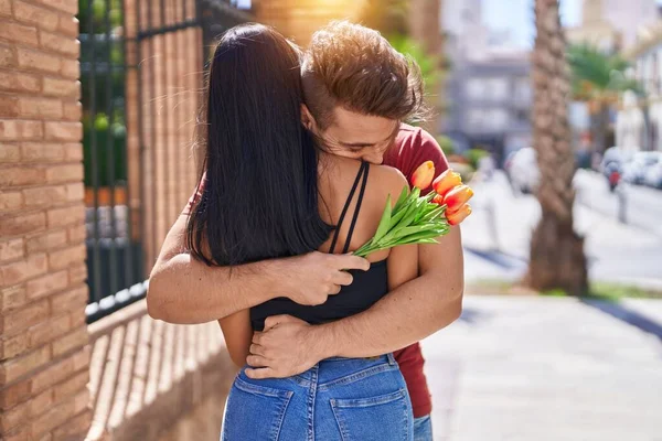 男人和女人在街上抱着一束鲜花互相拥抱 — 图库照片