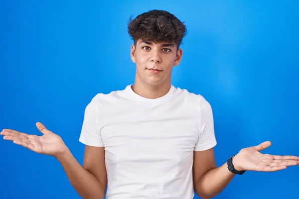Hispanic Teenager Standing Blue Background Clueless Confused Expression Arms Hands — ストック写真