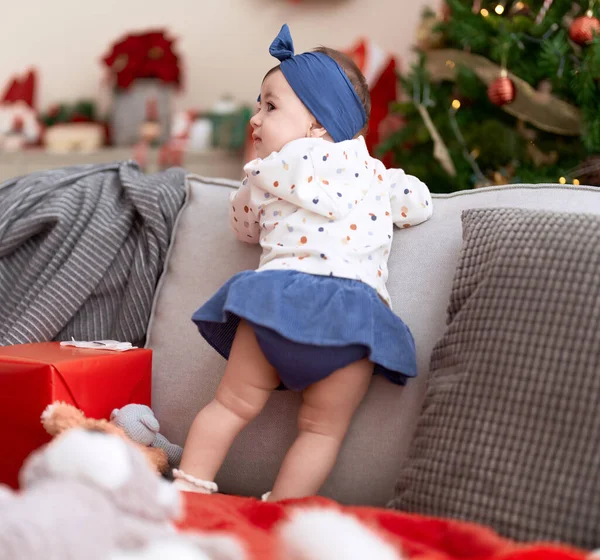可爱的幼儿站在家里的圣诞树旁的沙发上 — 图库照片