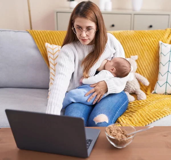 Anne Oğlu Evde Dizüstü Bilgisayar Kullanarak Bebek Emziriyor — Stok fotoğraf