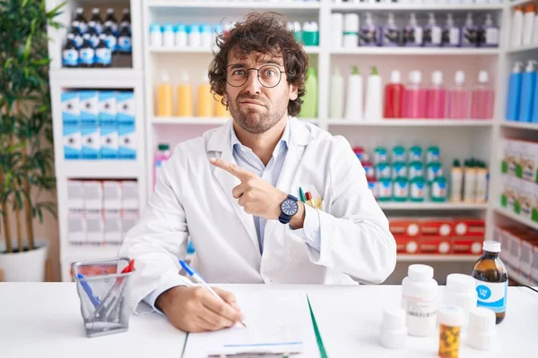 Hispanic Young Man Working Pharmacy Drugstore Pointing Aside Worried Nervous — Fotografia de Stock