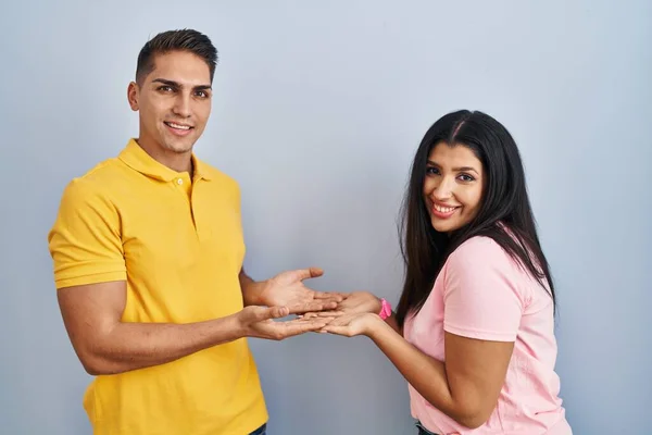 Young Couple Standing Isolated Background Pointing Aside Hands Open Palms — Stockfoto