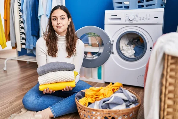 Young Hispanic Woman Holding Clean Laundry Puffing Cheeks Funny Face — 图库照片