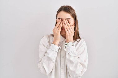 İzole edilmiş arka planda duran beyaz bir kadın yorgunluk ve baş ağrısı için gözlerini ovalıyor, uykulu ve yorgun bir ifade takınıyor. görme sorunu 