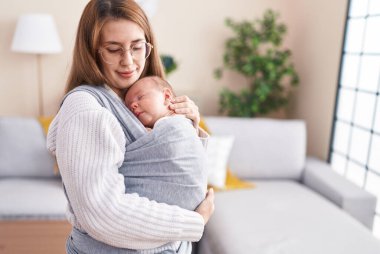 Anne ve oğul uyuyorlar bebek evde duruyor.