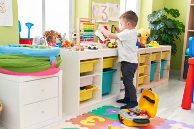 Adorable hispanic toddler playing at kindergarten