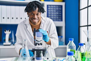 African american man scientist using microscope at laboratory