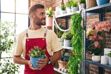 Çiçekçiye çiçek götürürken gülümseyen İspanyol bir çiçekçi.