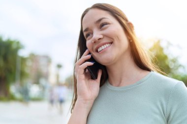 Young beautiful woman smiling confident talking on the smartphone at park