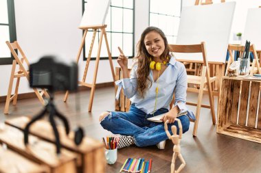 Güzel İspanyol kadın sanatçı gülümsüyor. Sanat stüdyosunda kendine güvenen çizim dersi alıyor.