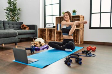 Evde esneme kursu aldığından emin bir şekilde gülümseyen genç İspanyol kadın.