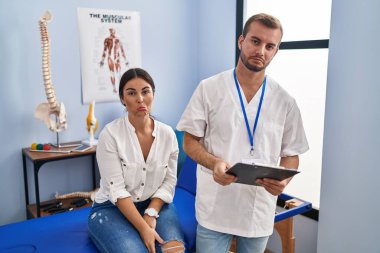 Young hispanic woman at physiotherapist appointment depressed and worry for distress, crying angry and afraid. sad expression. 