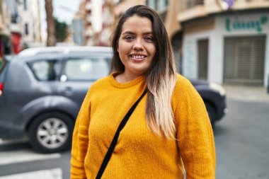 Young beautiful plus size woman smiling confident standing at street