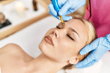 Genç beyaz kadın, güzellik salonunda mikroplu patinaj tedavisi görüyor.