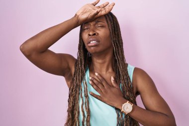 African american woman standing over pink background touching forehead for illness and fever, flu and cold, virus sick 