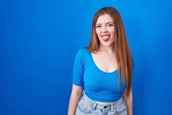 Redhead Woman Standing Blue Background Sticking Tongue Out Happy Funny — Stock Photo, Image