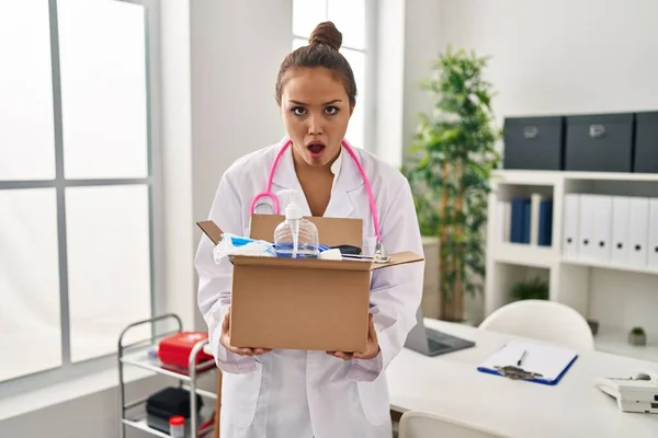 Young Hispanic Doctor Holding Box Medical Items Shock Face Looking — Stock Photo, Image