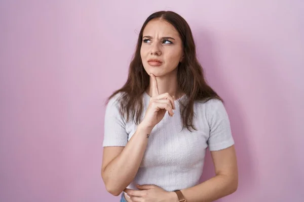 Young Hispanic Girl Standing Pink Background Thinking Concentrated Doubt Finger — Foto Stock