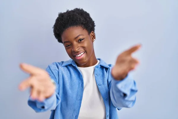 Африканская Американка Стоящая Синем Фоне Весело Улыбаясь Протягивает Руку Помощи — стоковое фото