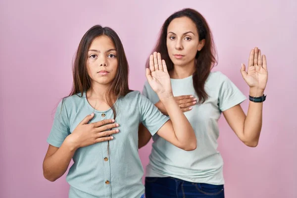 Young Mother Daughter Standing Pink Background Swearing Hand Chest Open — ストック写真