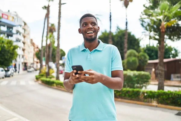 Nuori Afrikkalainen Amerikkalainen Mies Hymyilee Luottavainen Käyttämällä Älypuhelin Puistossa — kuvapankkivalokuva