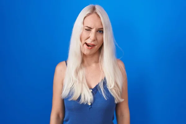Caucasian Woman Standing Blue Background Winking Looking Camera Sexy Expression — Fotografia de Stock