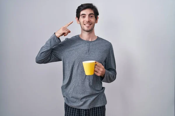 Young Hispanic Man Wearing Pajama Drinking Cup Coffee Smiling Pointing — Stock Photo, Image