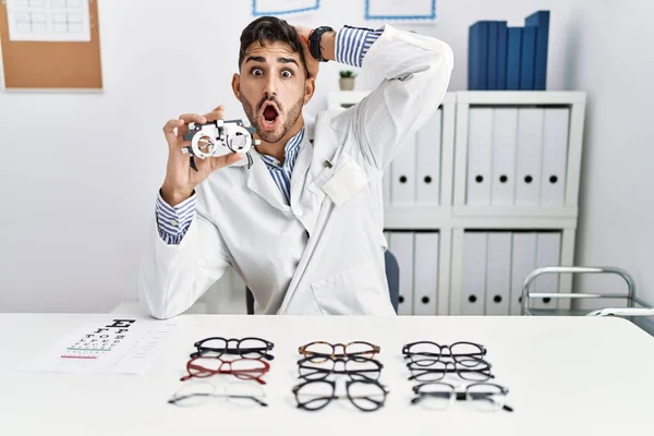 Young Optician Man Holding Optometry Glasses Crazy Scared Hands Head — 图库照片