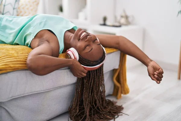 アフリカ系アメリカ人の女性は家でソファに横たわって音楽を聞いて — ストック写真