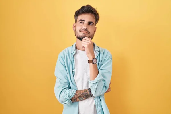 Junger Hispanischer Mann Mit Tätowierungen Vor Gelbem Hintergrund Die Hand — Stockfoto