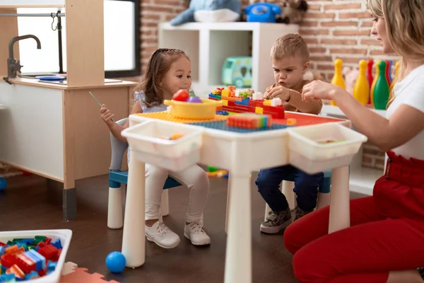 Teacher Boy Girl Playing Construction Blocks Sitting Table Kindergarten — Zdjęcie stockowe