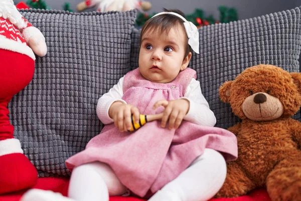 可爱的婴儿坐在沙发上 坐在家里的圣诞装饰品旁玩马拉卡游戏 — 图库照片