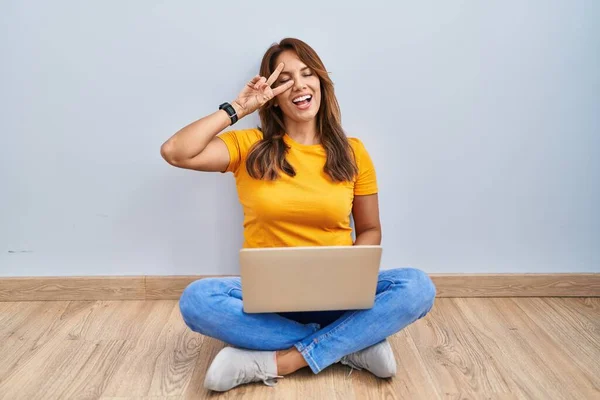 Hispanic Woman Using Laptop Sitting Floor Home Doing Peace Symbol —  Fotos de Stock